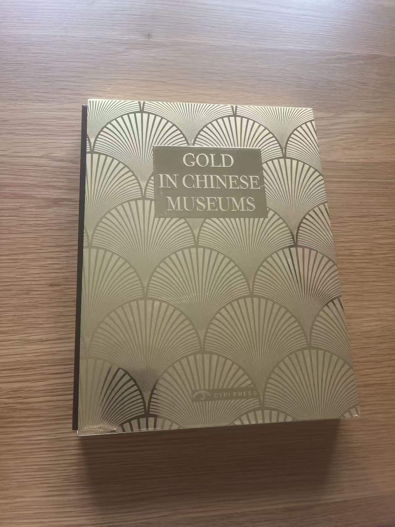 收到的 Gold in Chinese Museums 译者样书，金色封面放在木桌上